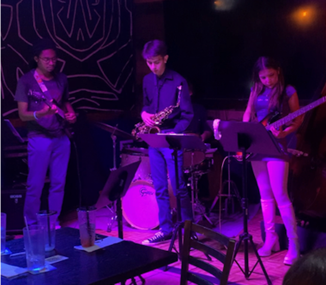 Trio performing under purple lighting